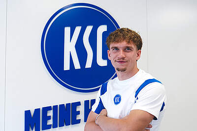Julian Gerold vor dem KSC-Logo