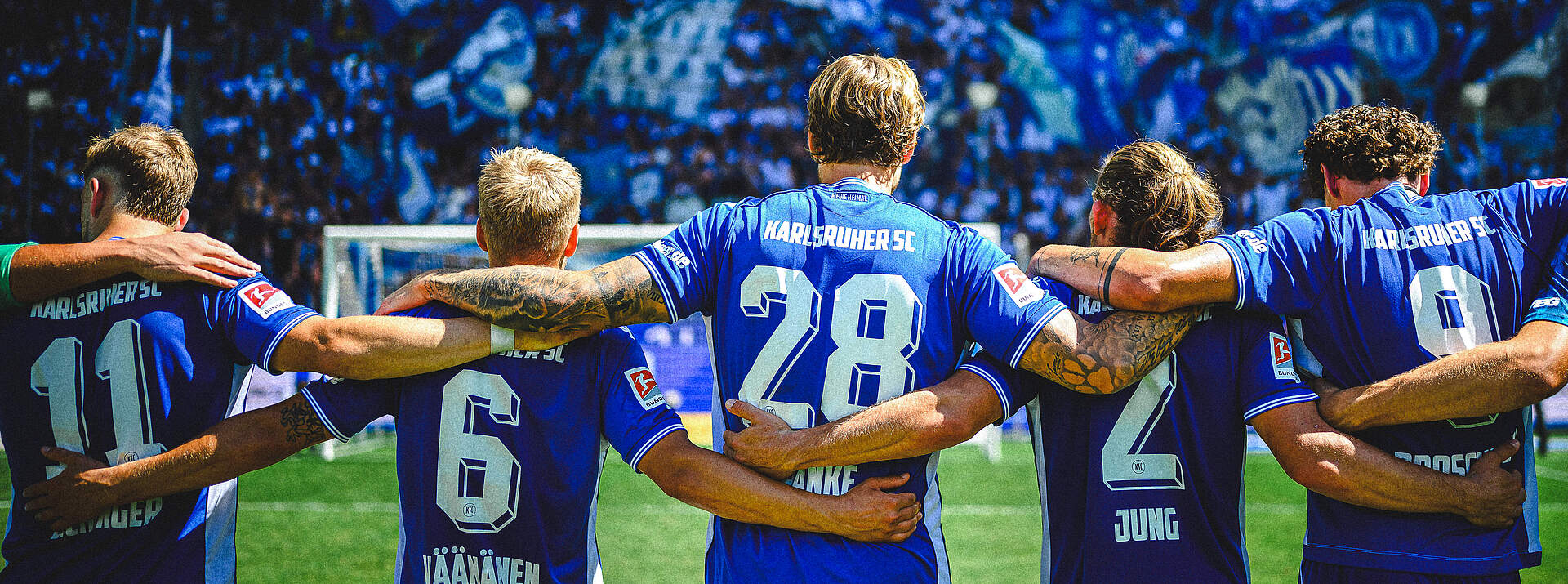KSC-Spieler Arm in Arm vor den Fans