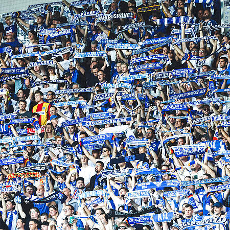 Fans halten ihre Schals im Stadion hoch.