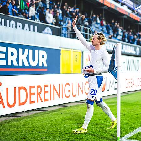 David Herold hat sein Trikot ausgezogen und winkt zu den Fans.