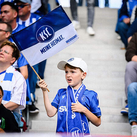Ein Junge im BBBank Wildpark schwenkt eine KSC-Fahne