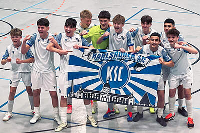 Die U15 bejubelt ihren Turniersieg mit einer KSC-Zaunfahne